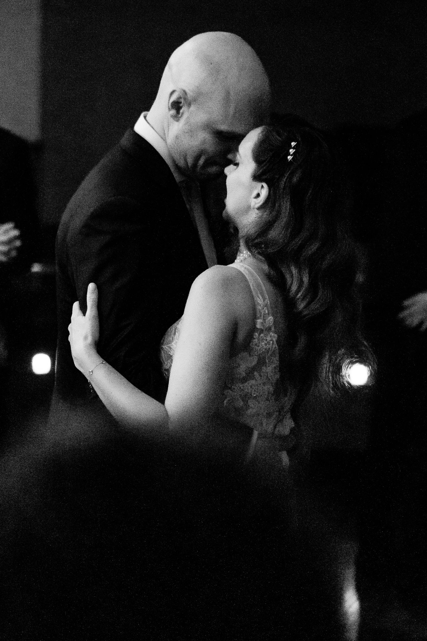 Black and white photo of a couple sharing an intimate first dance at their wedding reception.