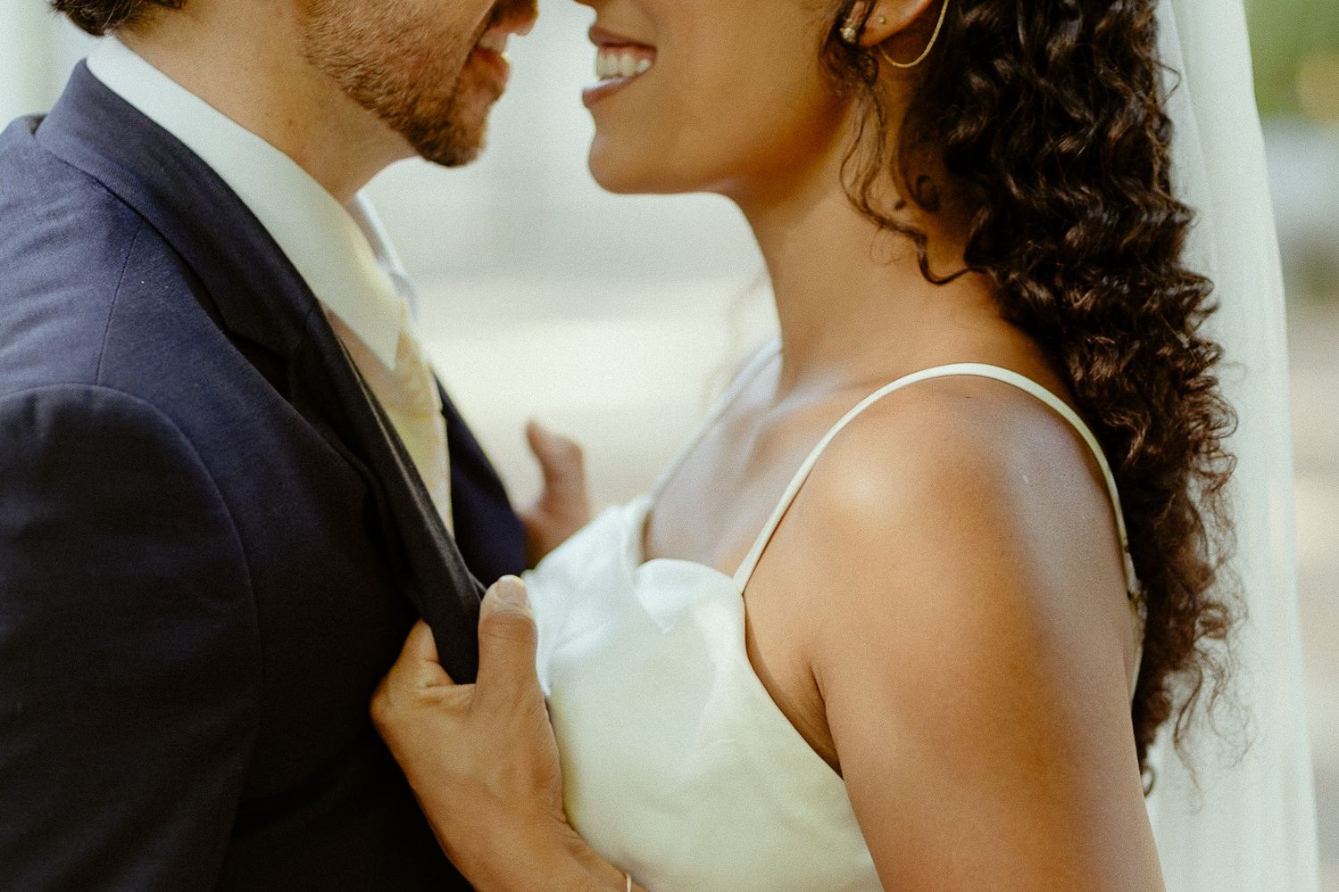 A bride and groom share a romantic moment, with the bride in a white dress and groom in a navy suit.