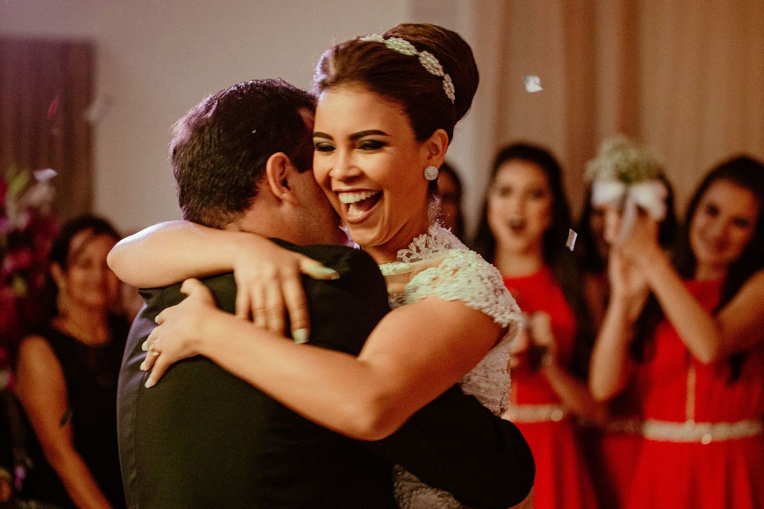 Warm-toned wedding reception photo capturing joyful dancing and celebration.
