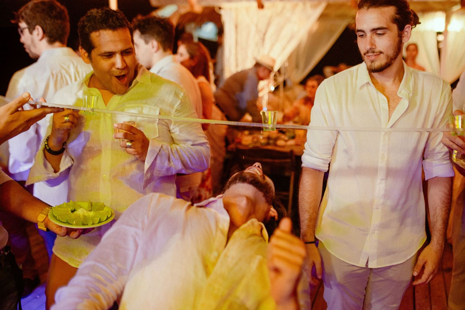 People dancing and enjoying themselves at a lively party in warm ambient lighting.