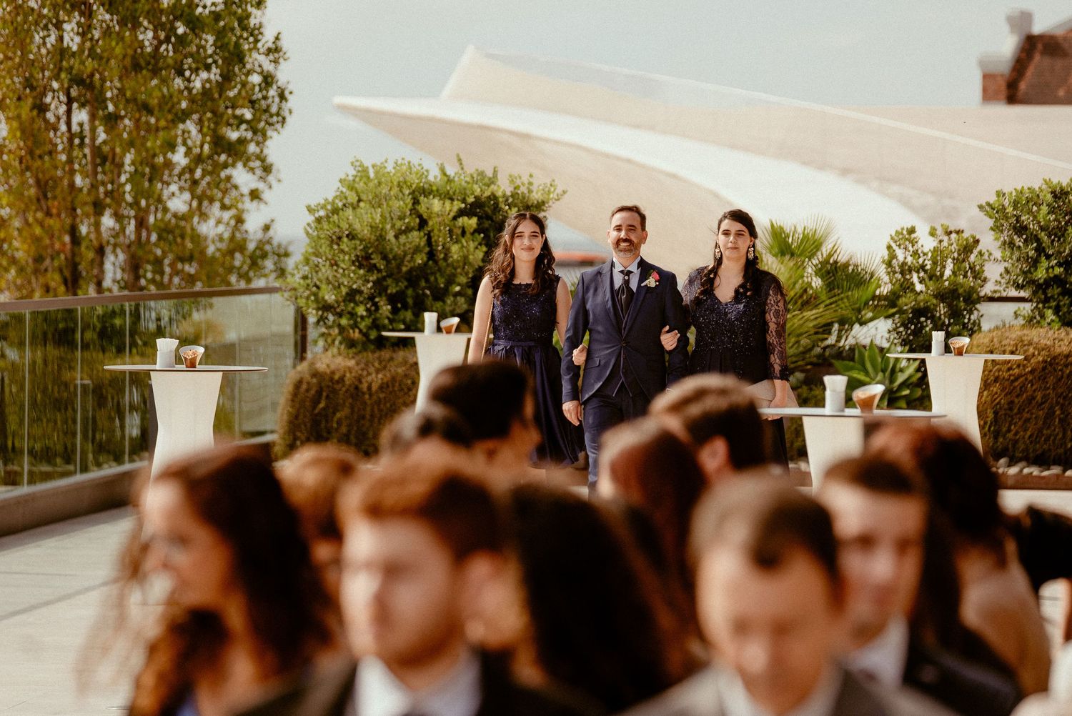 A cinematic wedding ceremony scene captured at sunset with soft golden light filtering through the trees.