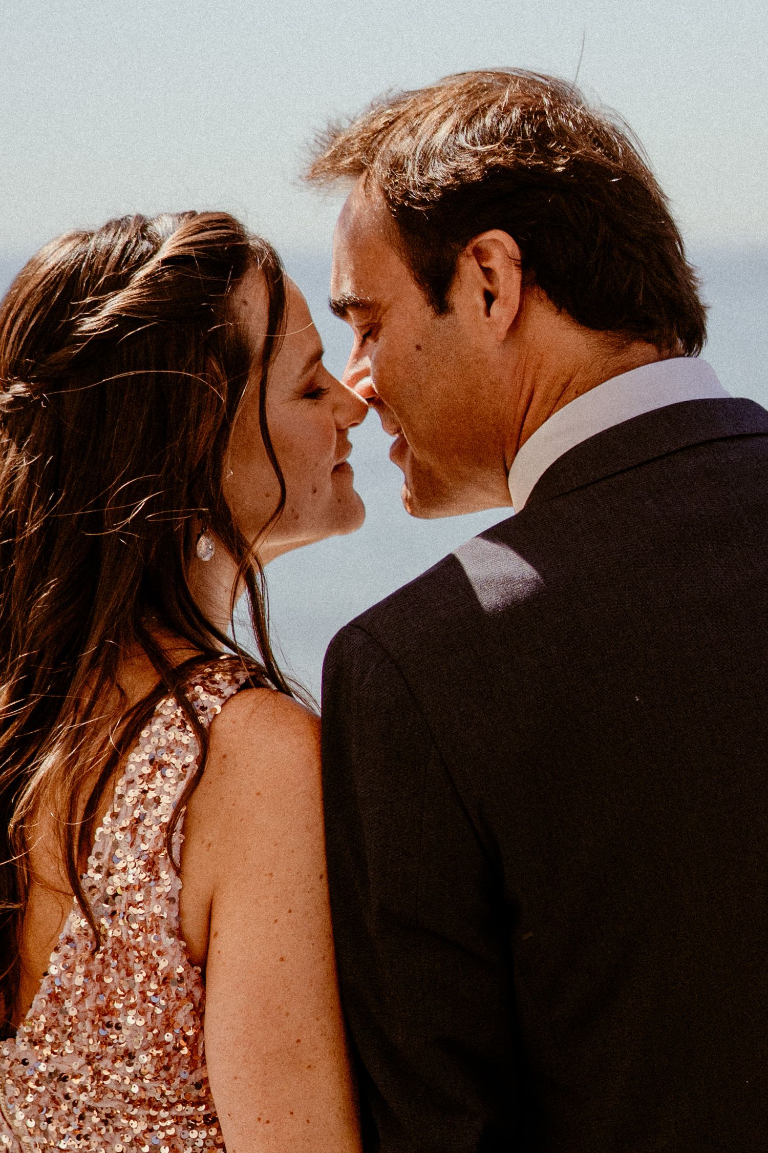 A romantic close-up of a couple about to kiss in golden sunlight.