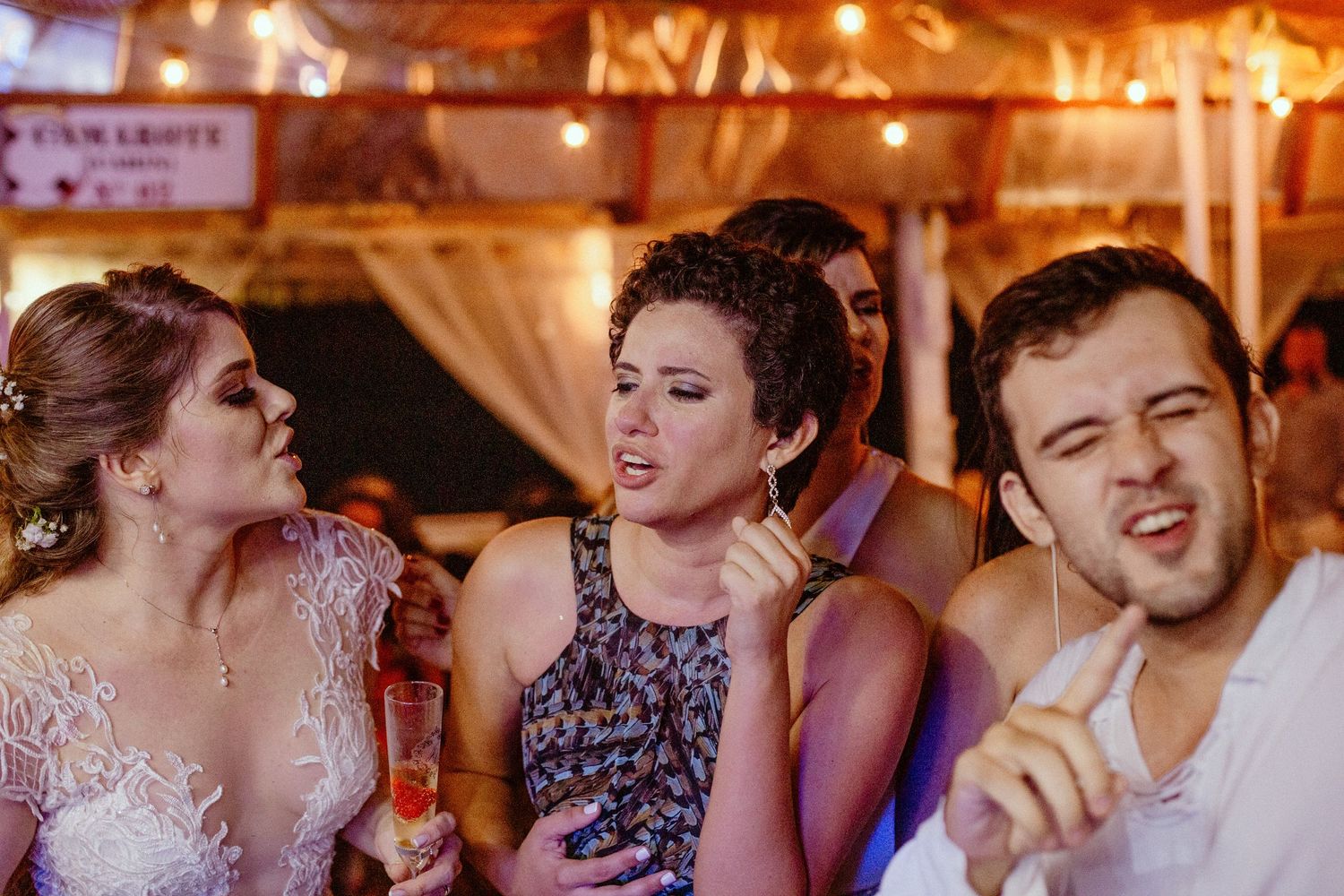 Wedding guests enjoying themselves during a festive reception celebration at an indoor venue.
