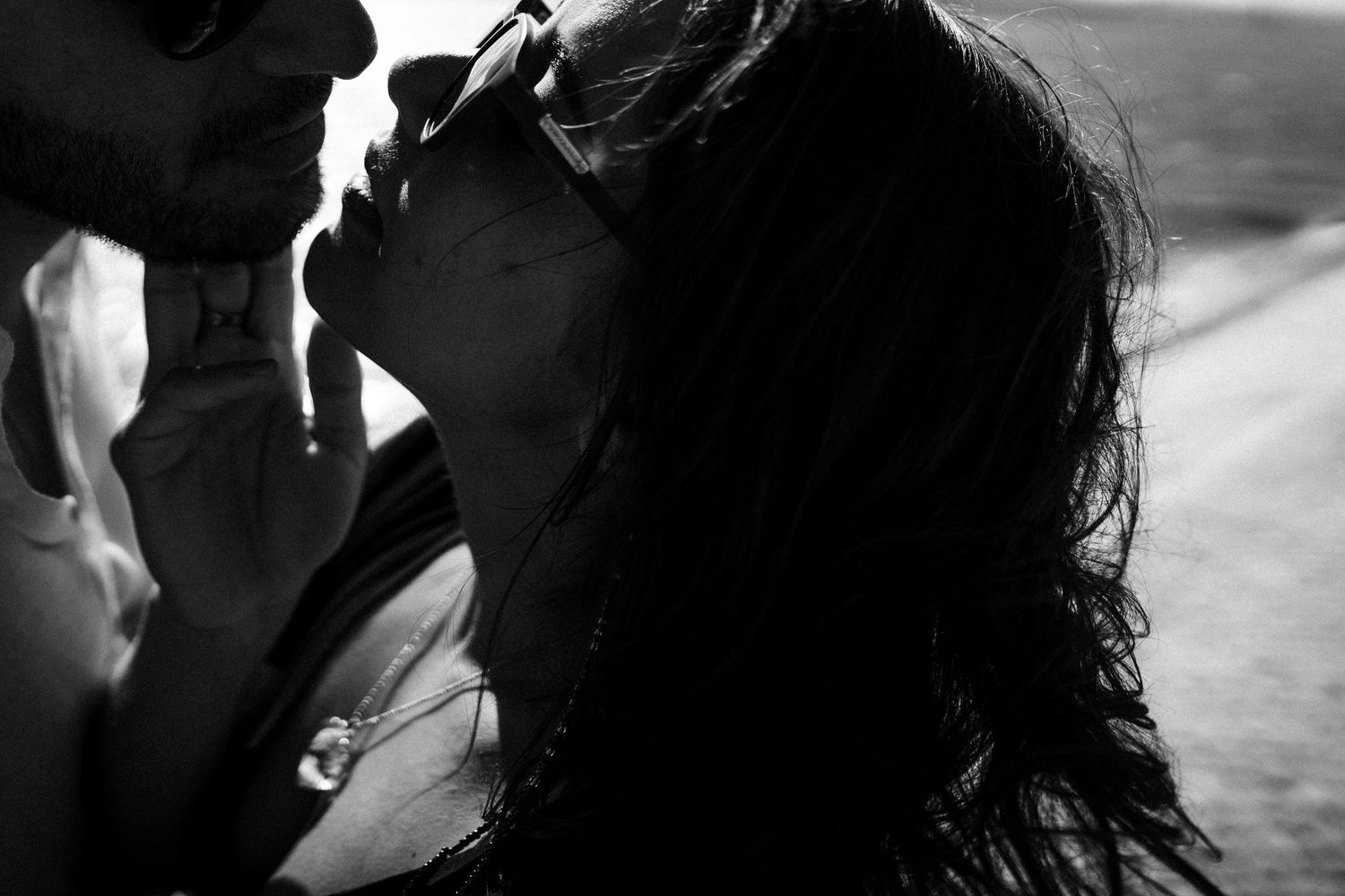 A silhouetted couple sharing an intimate moment in black and white photography.