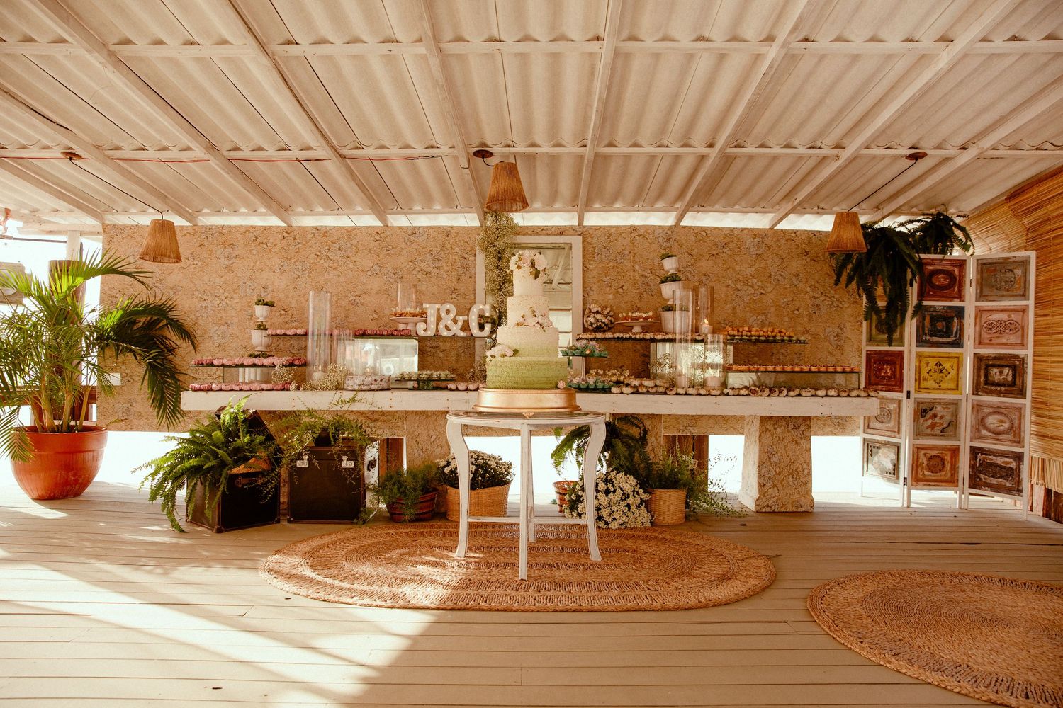Warm bohemian living space with rattan rugs, potted plants, and natural light streaming through a white covered patio.