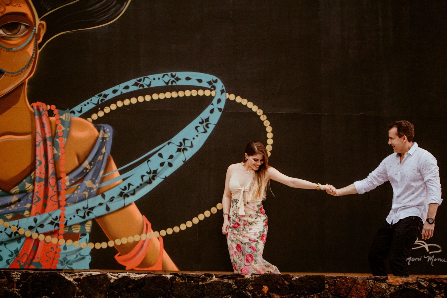 Dancers perform an elegant synchronized choreography on a dark stage illuminated by dramatic lighting.