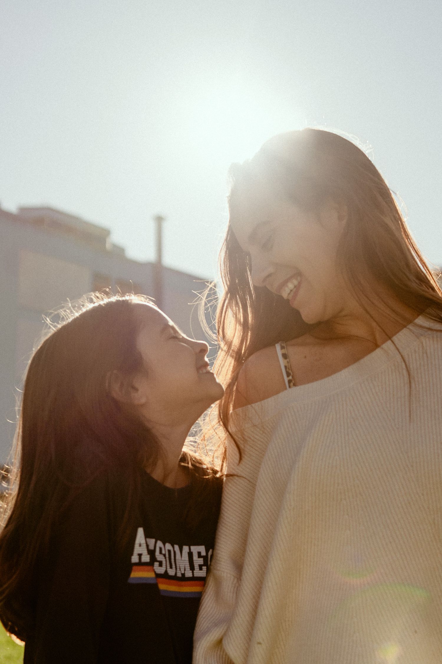 A sun-drenched silhouette shows a romantic couple in an intimate moment with golden backlight creating a dreamy atmosphere.