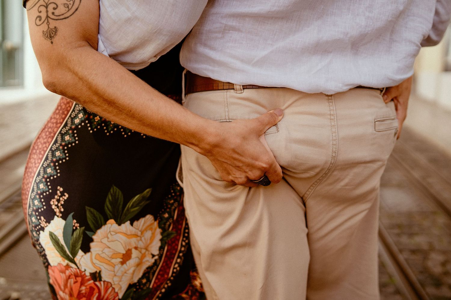 Close up shot of a couple's hands and rings during an intimate coastal wedding ceremony at sunset.