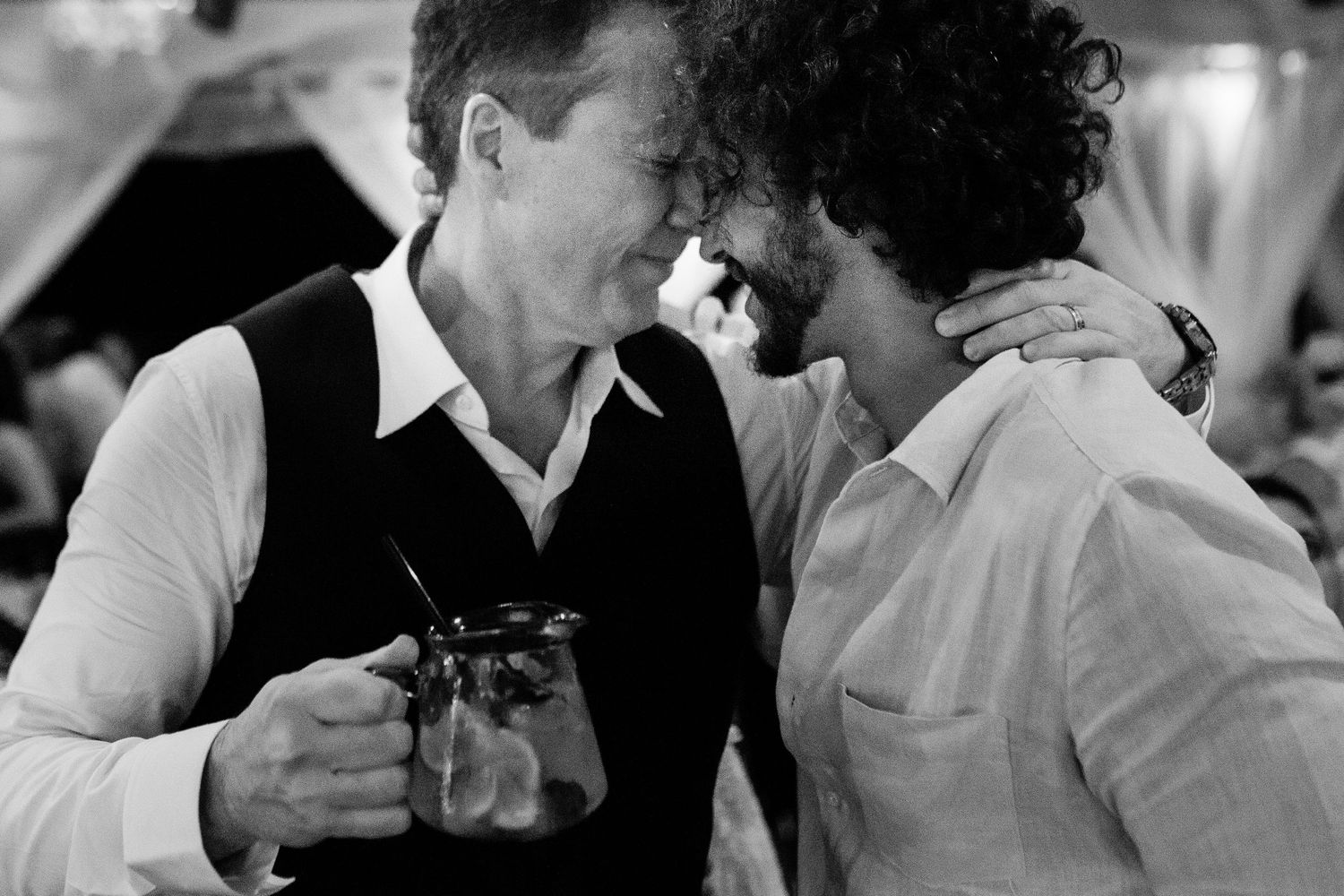 Black and white photo strip showing four intimate candid moments between people at social gatherings.