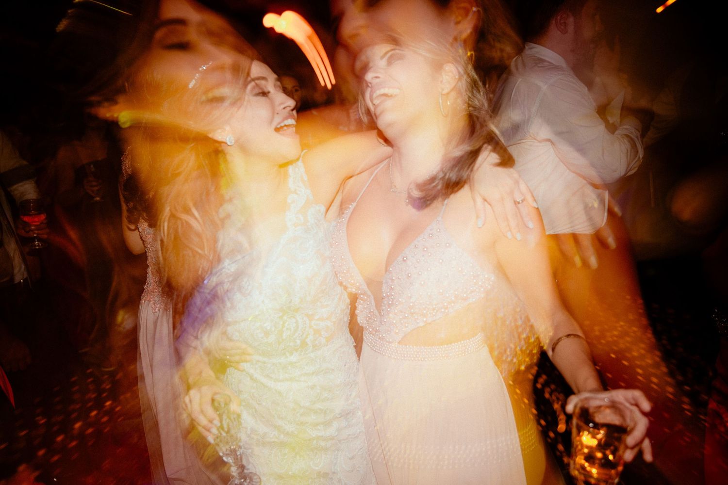 Dance floor filled with people celebrating at a lively party with atmospheric lighting effects.