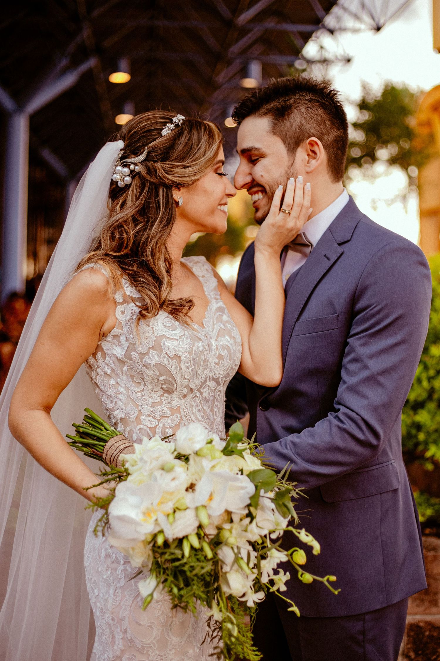 Romantic wedding portrait with bride holding white bouquet in intimate pose.