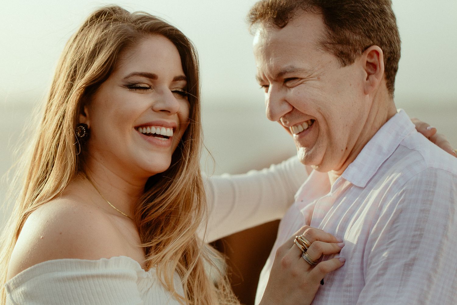 A couple shares joyful moments together during a romantic outdoor photo session at sunset.