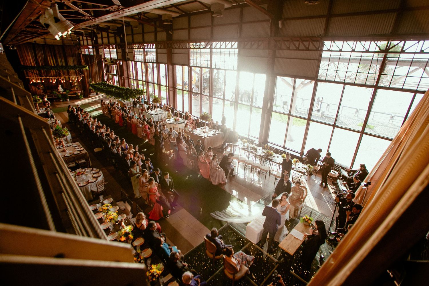 Panoramic view of a bustling school cafeteria filled with students during lunch hour with natural light streaming in.