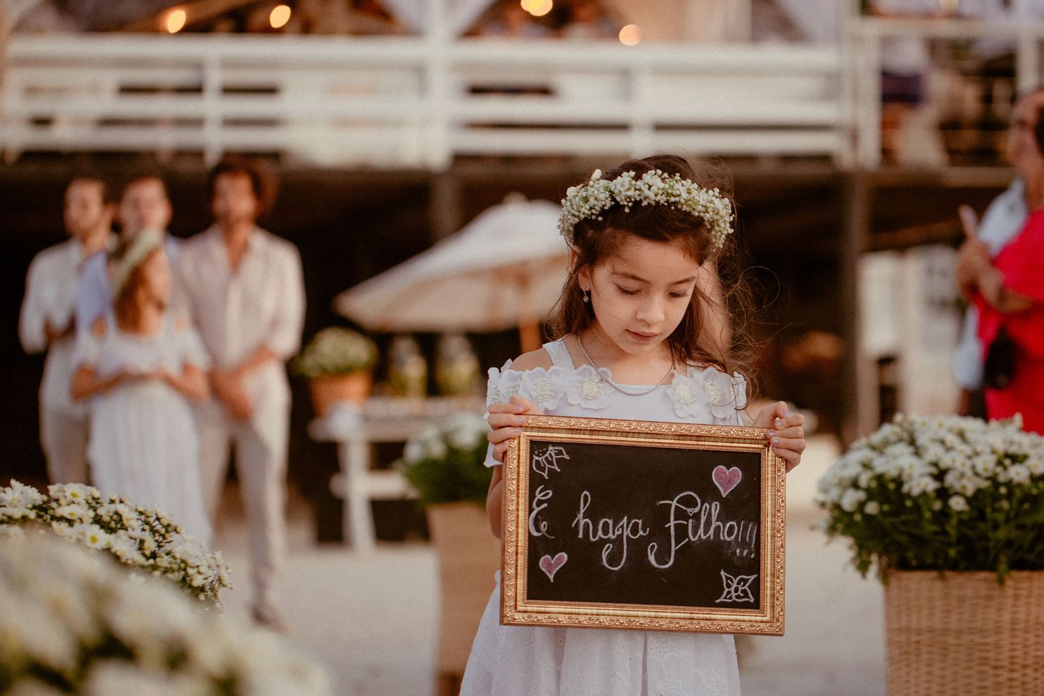 Rustic wedding reception decor with hanging lights and table settings in an outdoor venue.