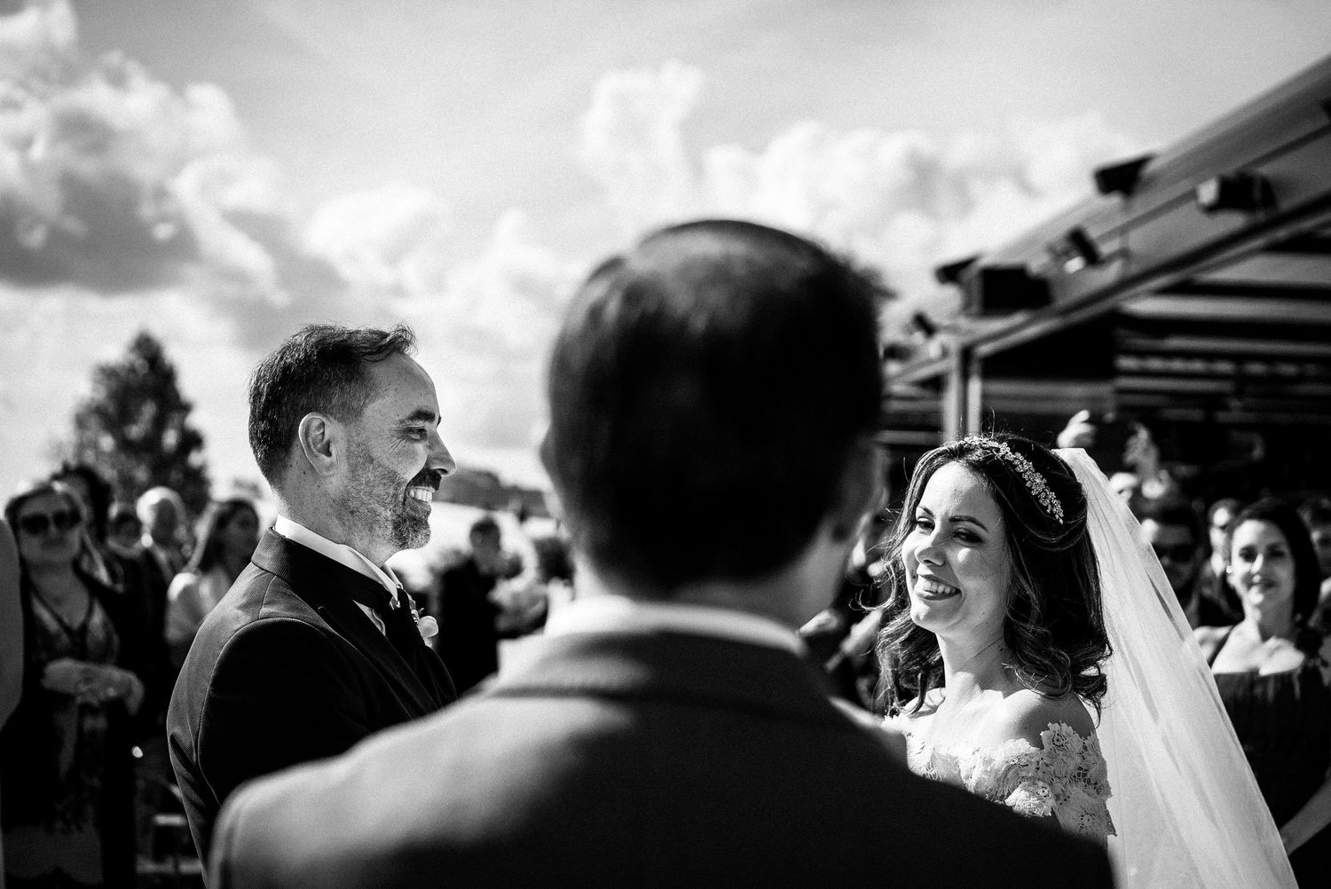 Black and white capture of joyful wedding ceremony moment outdoors.