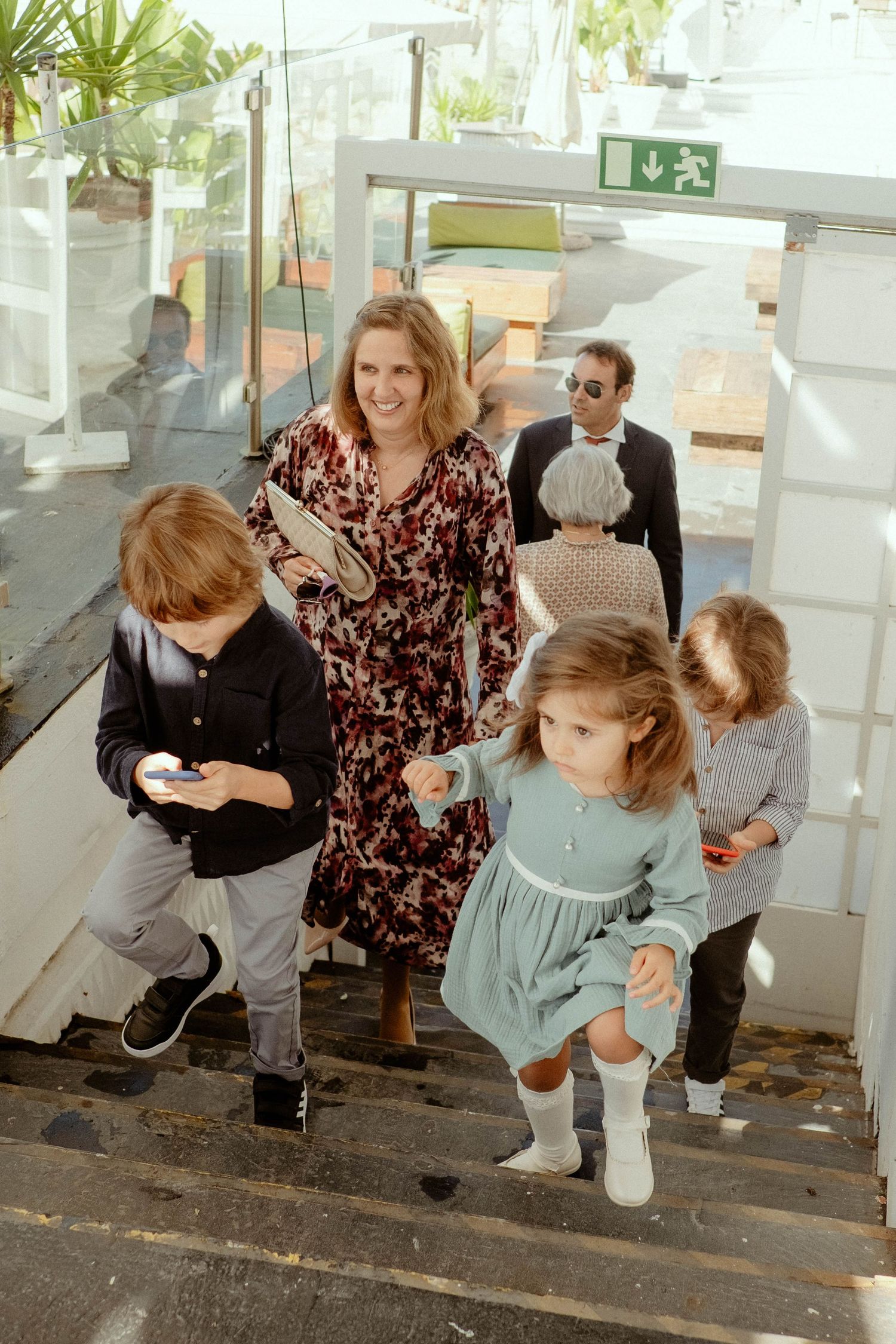A sequence of four connected photos showing people sitting on steps in casual conversation and interaction.