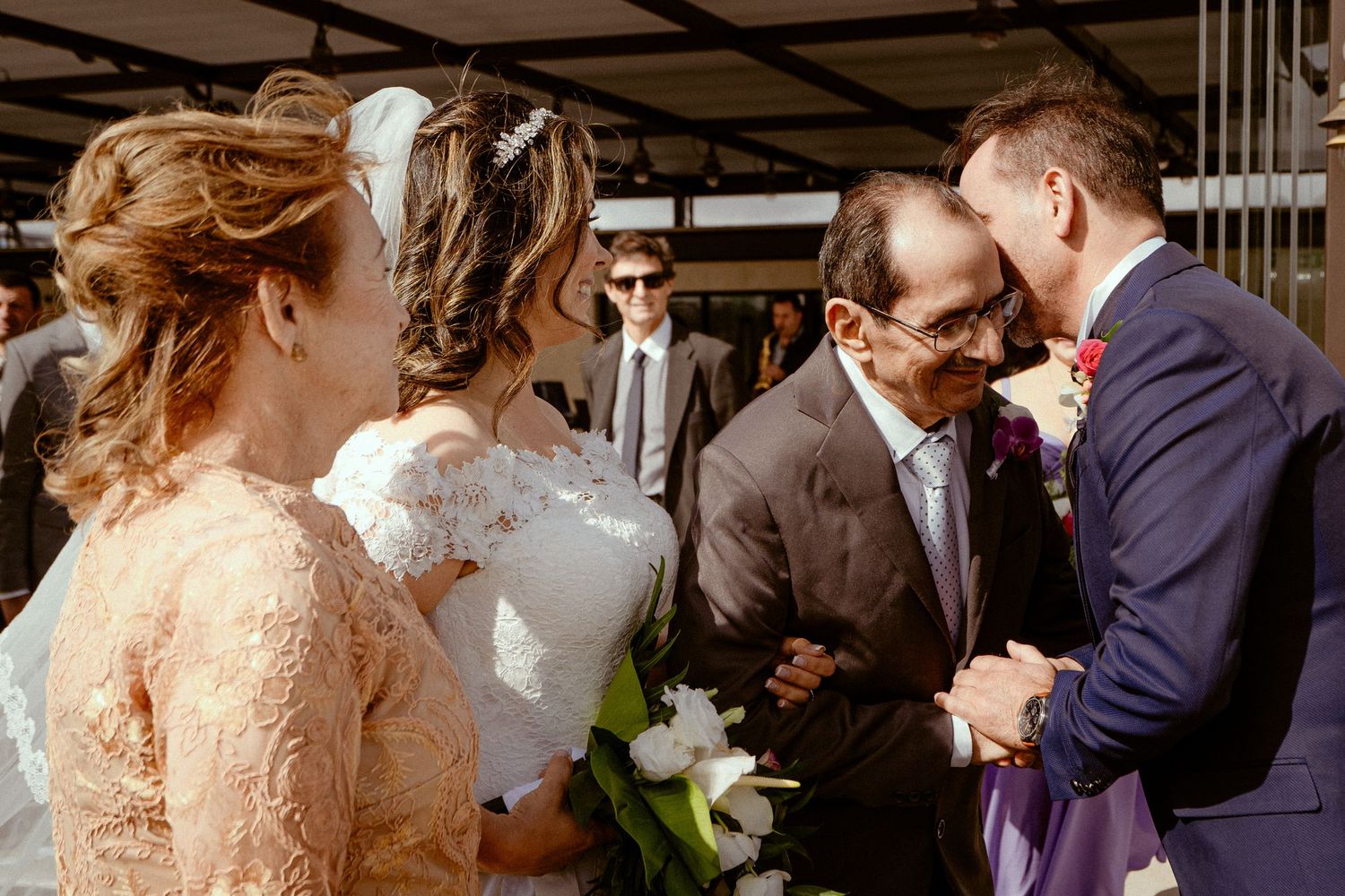 Wedding celebration as a couple embraces and kisses while guests watch and applaud during the reception.