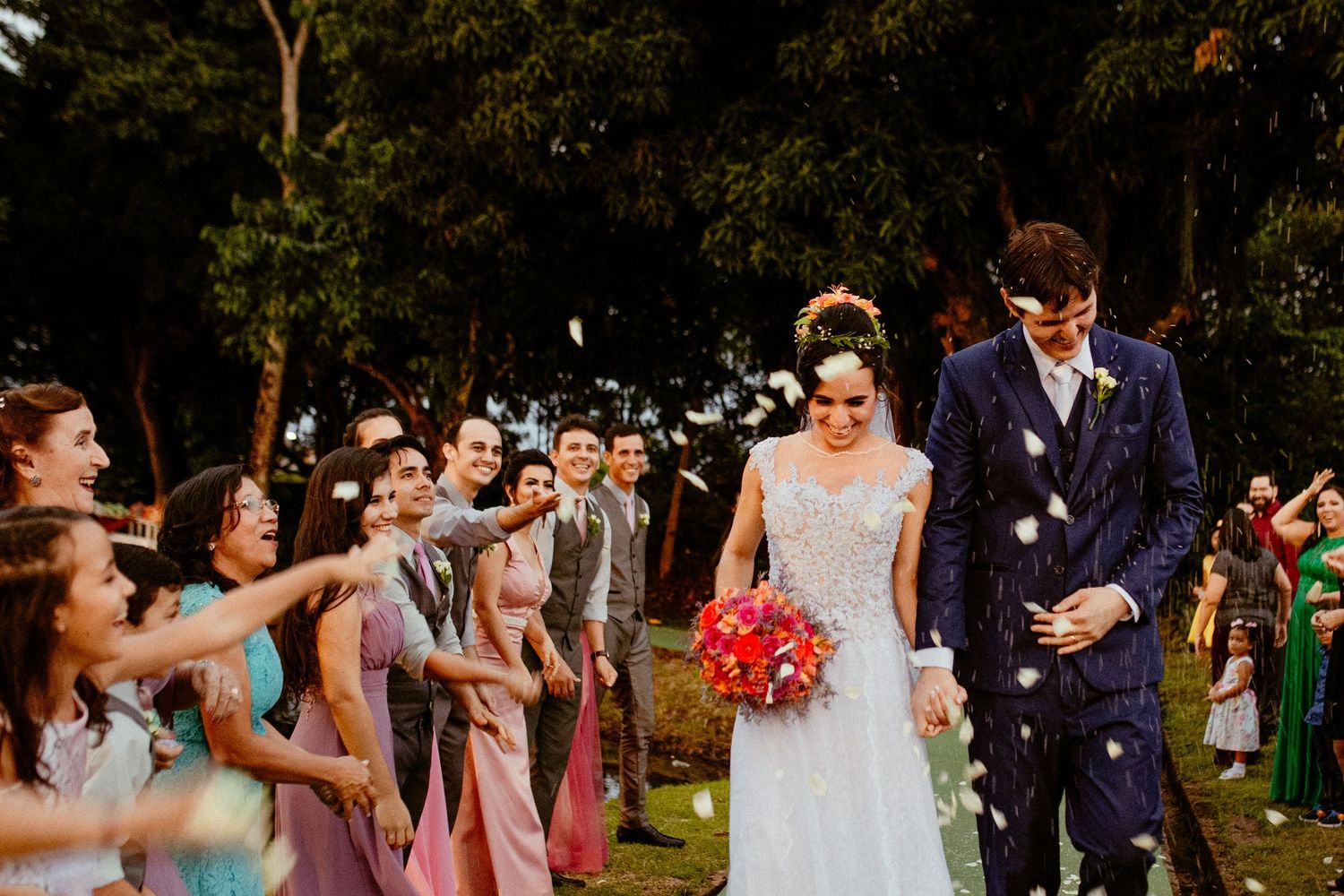 Collage of five festive outdoor wedding photographs showing joyful ceremony and reception moments with guests celebrating.
