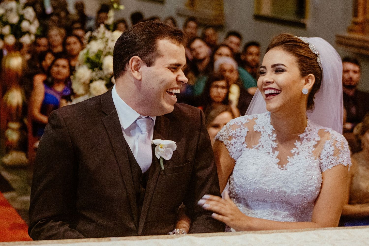 A couple share a joyful moment during their wedding ceremony in a church.
