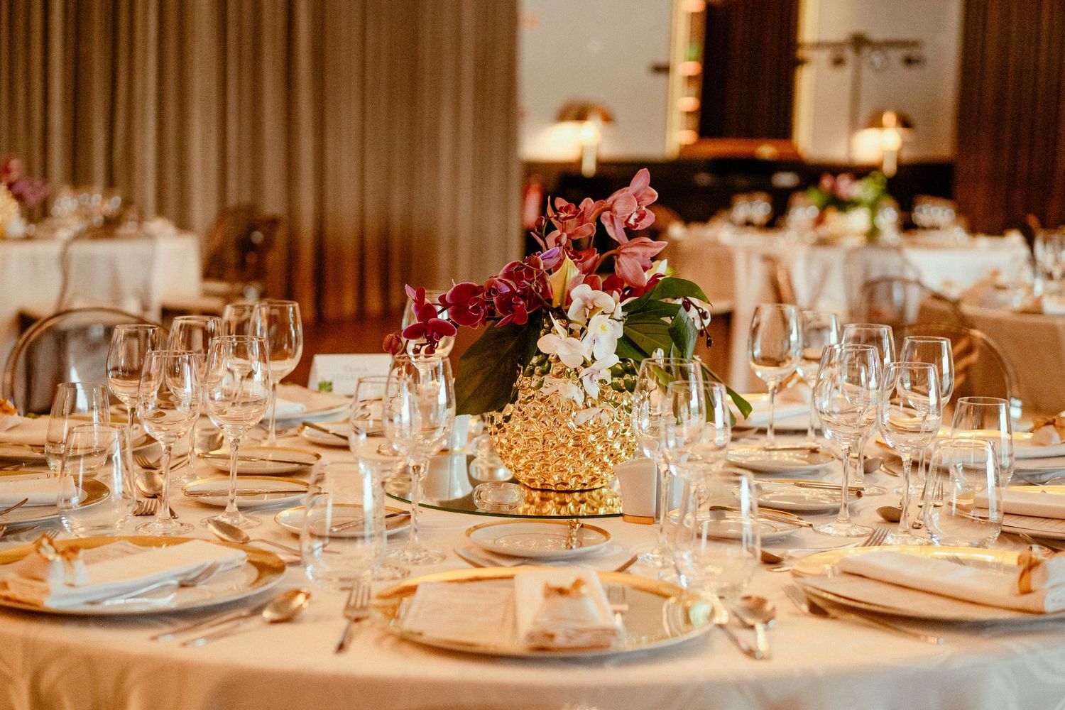 Elegant wedding table setting with floral centerpiece and crystal glassware.