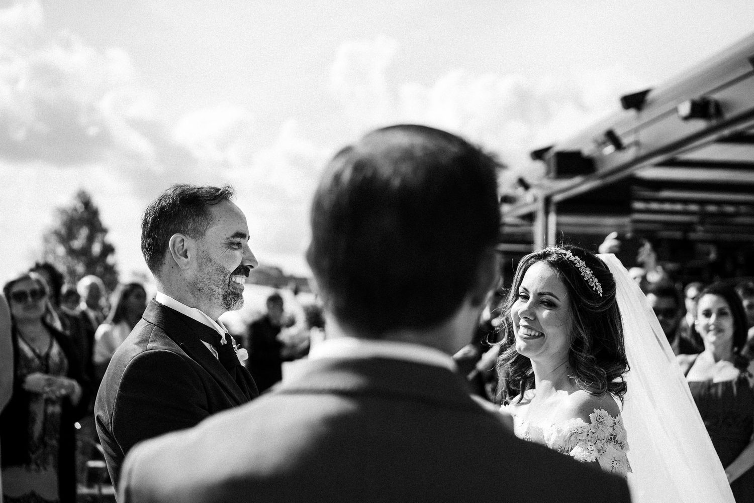 A series of wedding photos depicting candid moments between couples and guests during an outdoor ceremony.