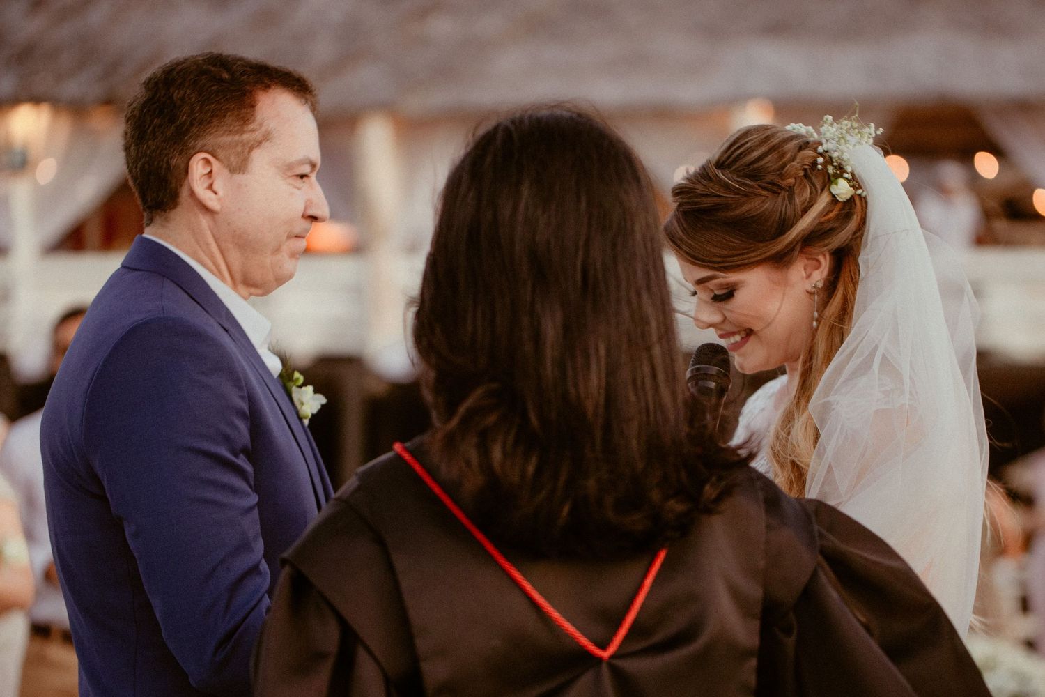 Wedding guests share joyful laughter and celebration during an outdoor reception.