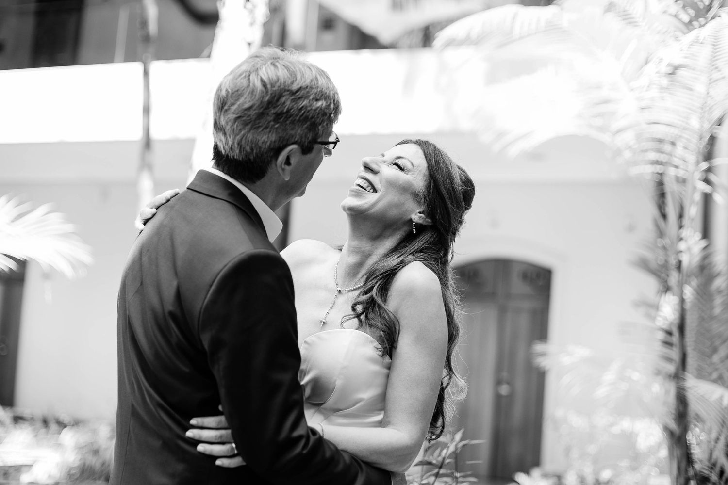 A black and white collage of romantic wedding moments showing couples embracing and kissing during their celebrations.
