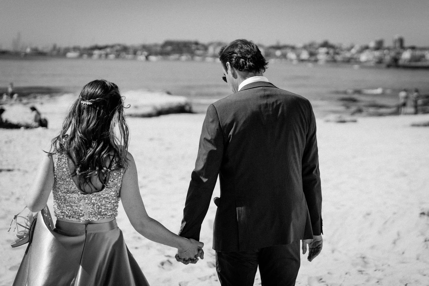 A black and white photo montage shows couples walking hand in hand along a beach in romantic poses.