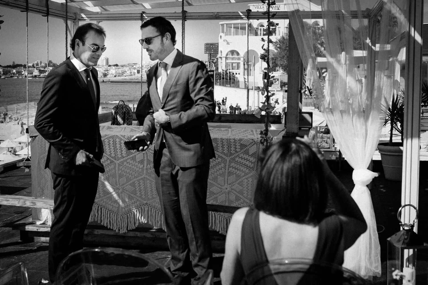 A series of black and white photographs showing people in formal business attire having conversations in an office setting.