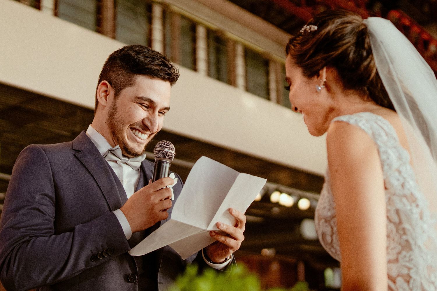 Wedding guests reading cards and sharing emotional reactions at an outdoor celebration.