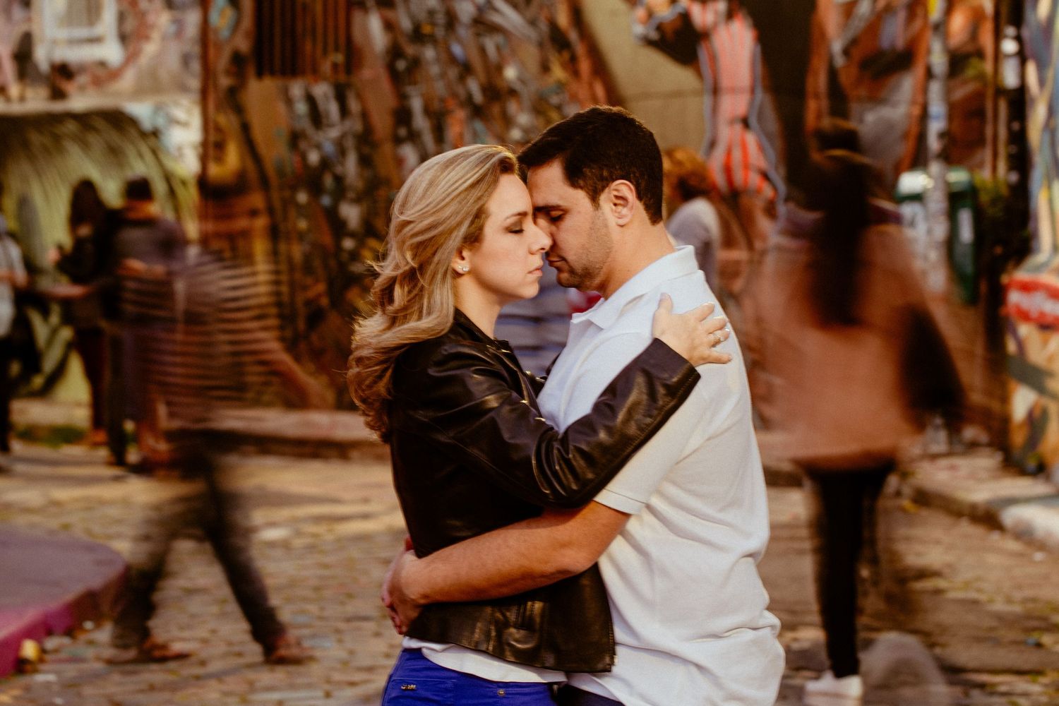 Romantic couple dances intimately in an urban street filled with colorful lanterns and brick buildings.