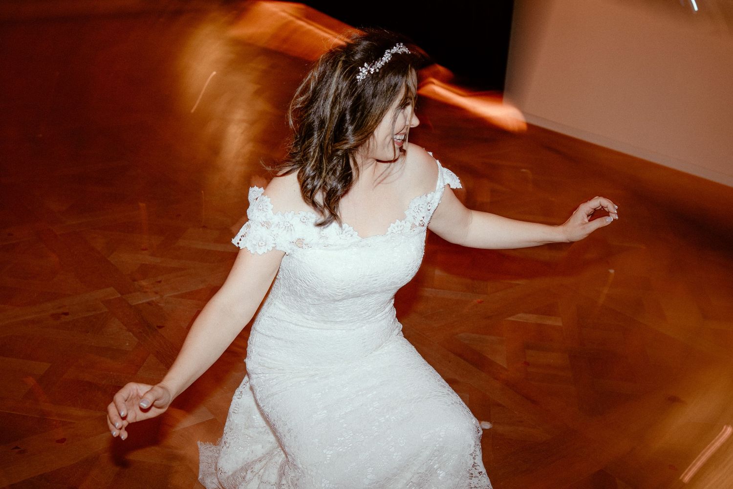 A series of dance moves are captured showing graceful twirls in a flowing white dress on a hardwood floor.