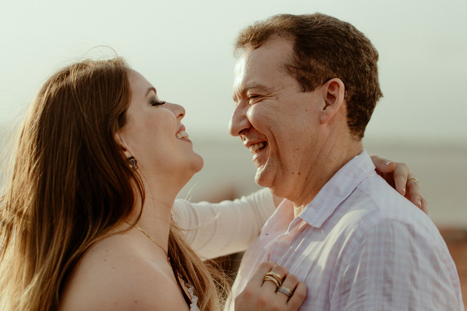 A couple shares joyful moments together in a romantic outdoor setting during golden hour lighting.