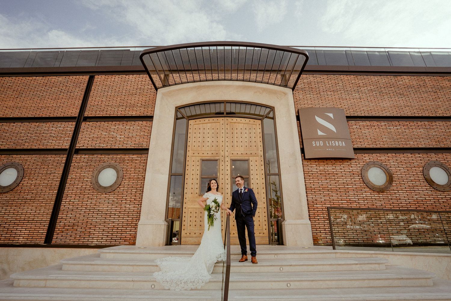 Panoramic view of a modern brick building exterior with industrial-style lighting fixtures and architectural details.