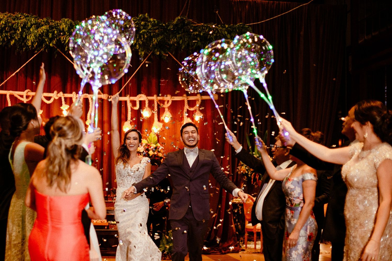 Wedding guests celebrate on the dance floor with sparklers and confetti during an evening reception celebration.