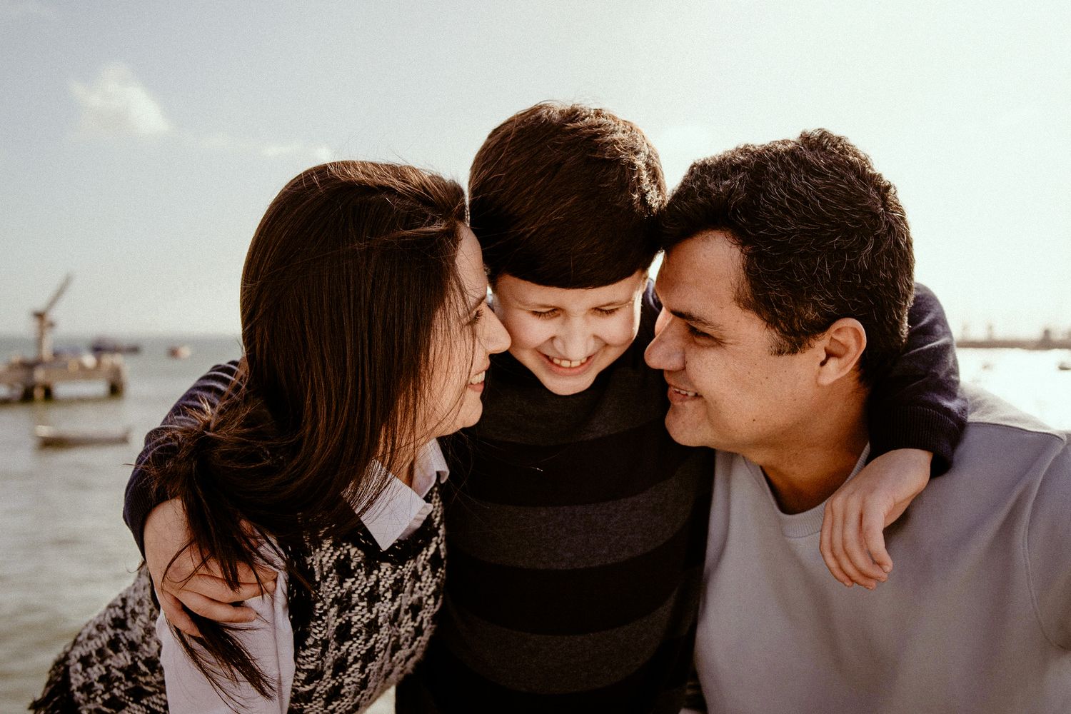 An intimate family moment captured by the water on a sunny day.