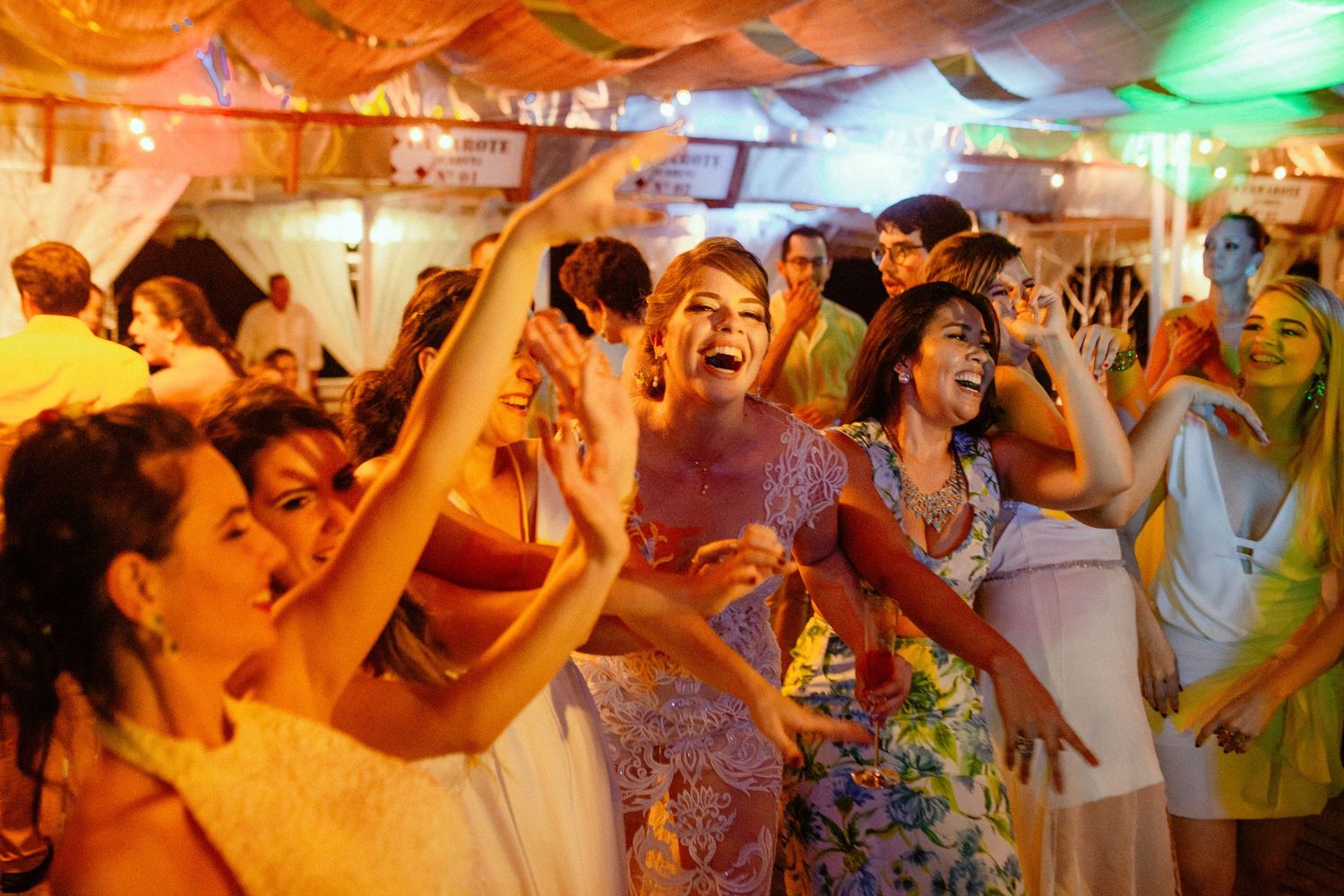 A series of colorful party scenes with dancing people in a nightclub setting illuminated by orange and green lights.