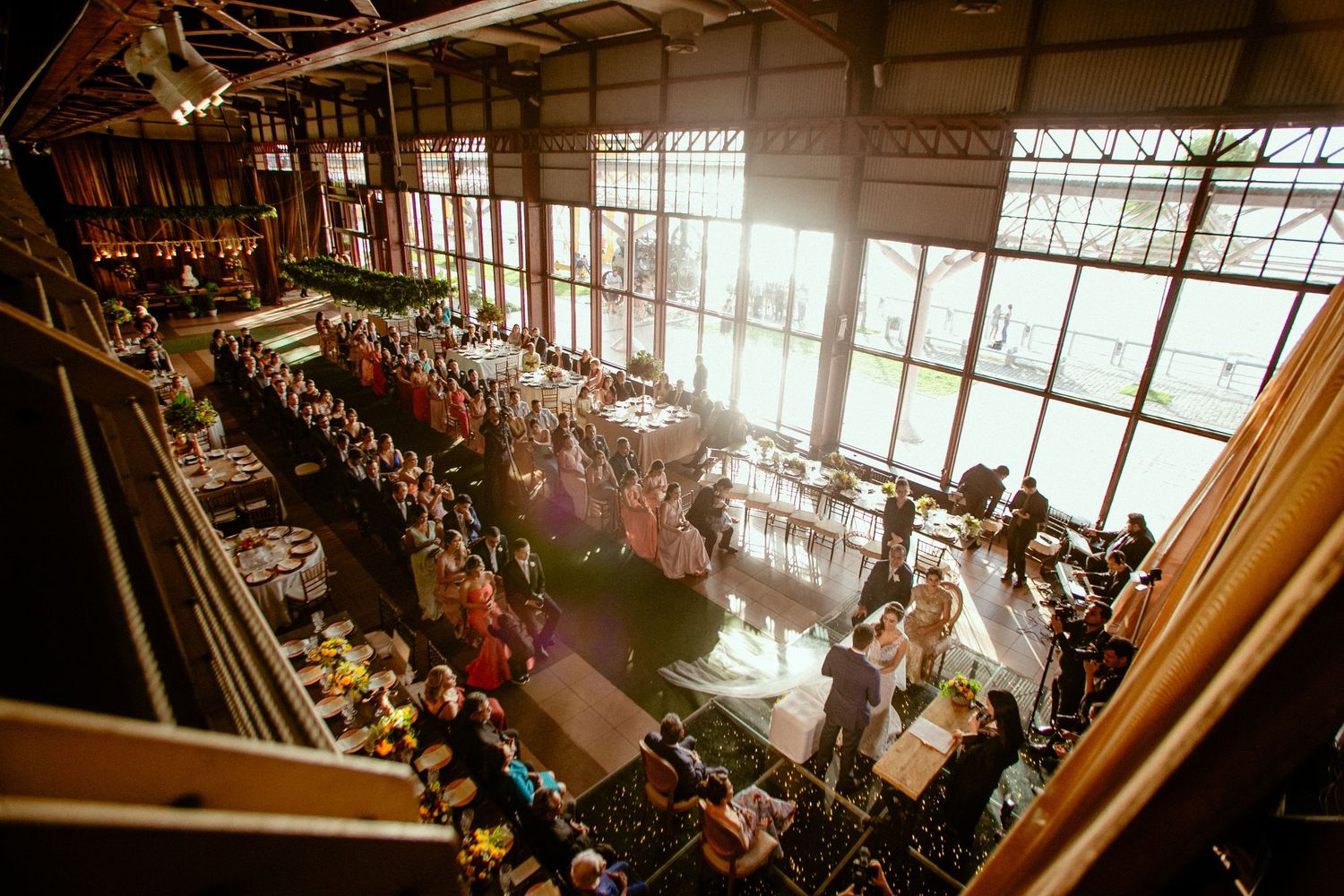 An aerial view of an elegant wedding reception venue with large windows and natural light.
