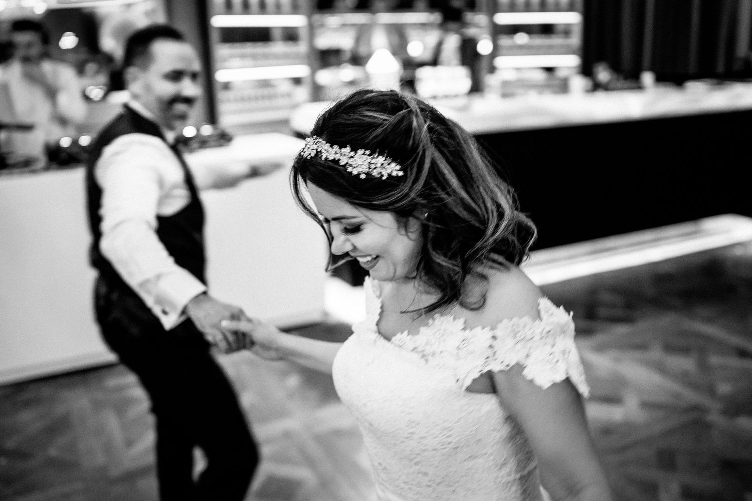A collection of black and white wedding photos showing dancing, candid moments and celebration at a reception.