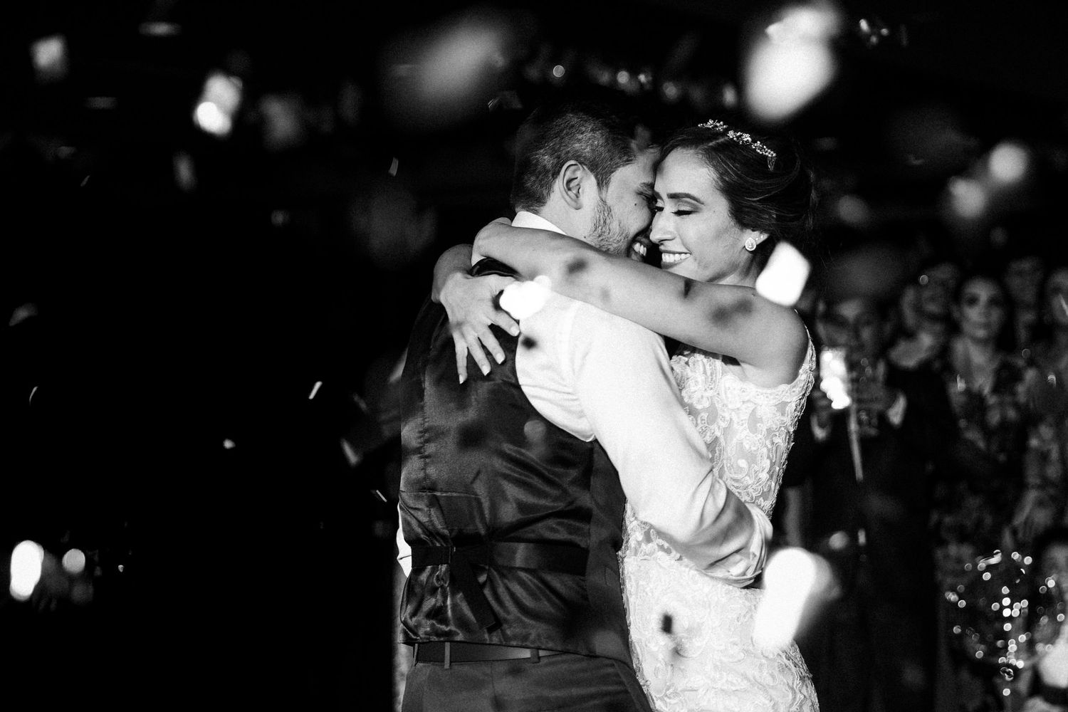 A romantic black and white photo showing a couple sharing an intimate dance moment during a celebration.