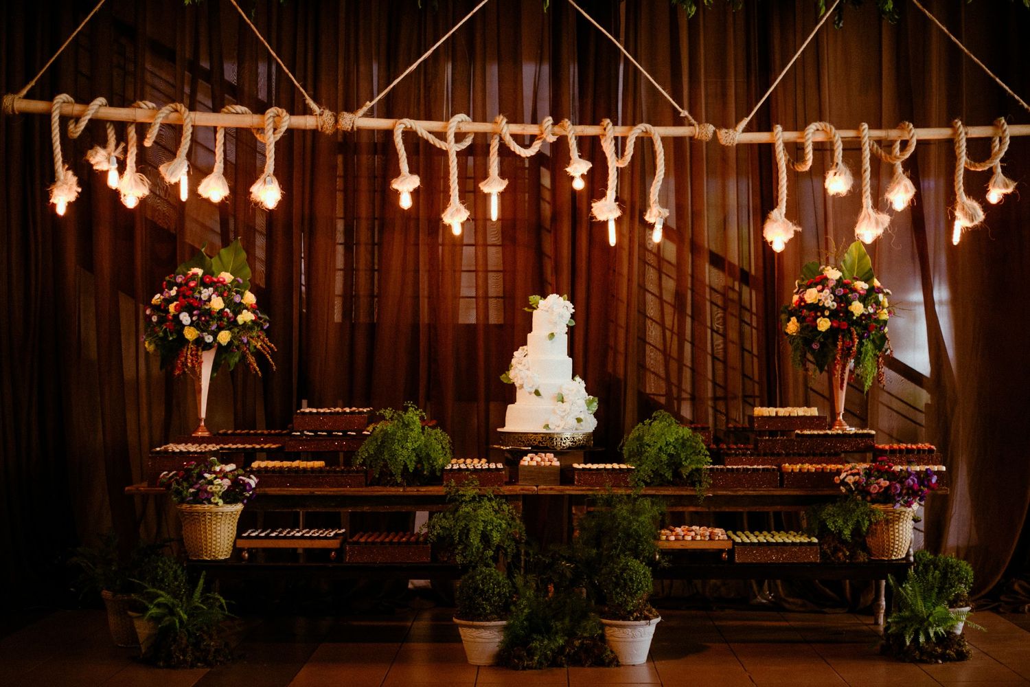 Rustic barn wedding reception venue with string lights, wooden beams, and elegant table settings creating a cozy atmosphere.