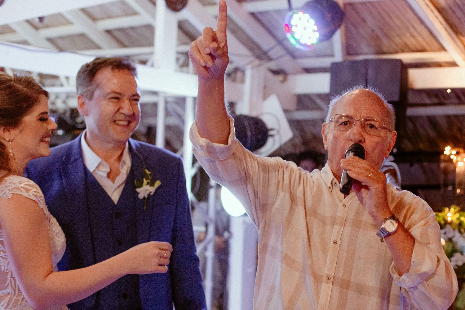 Wedding guests celebrate and dance together on a lively dance floor at an evening reception.