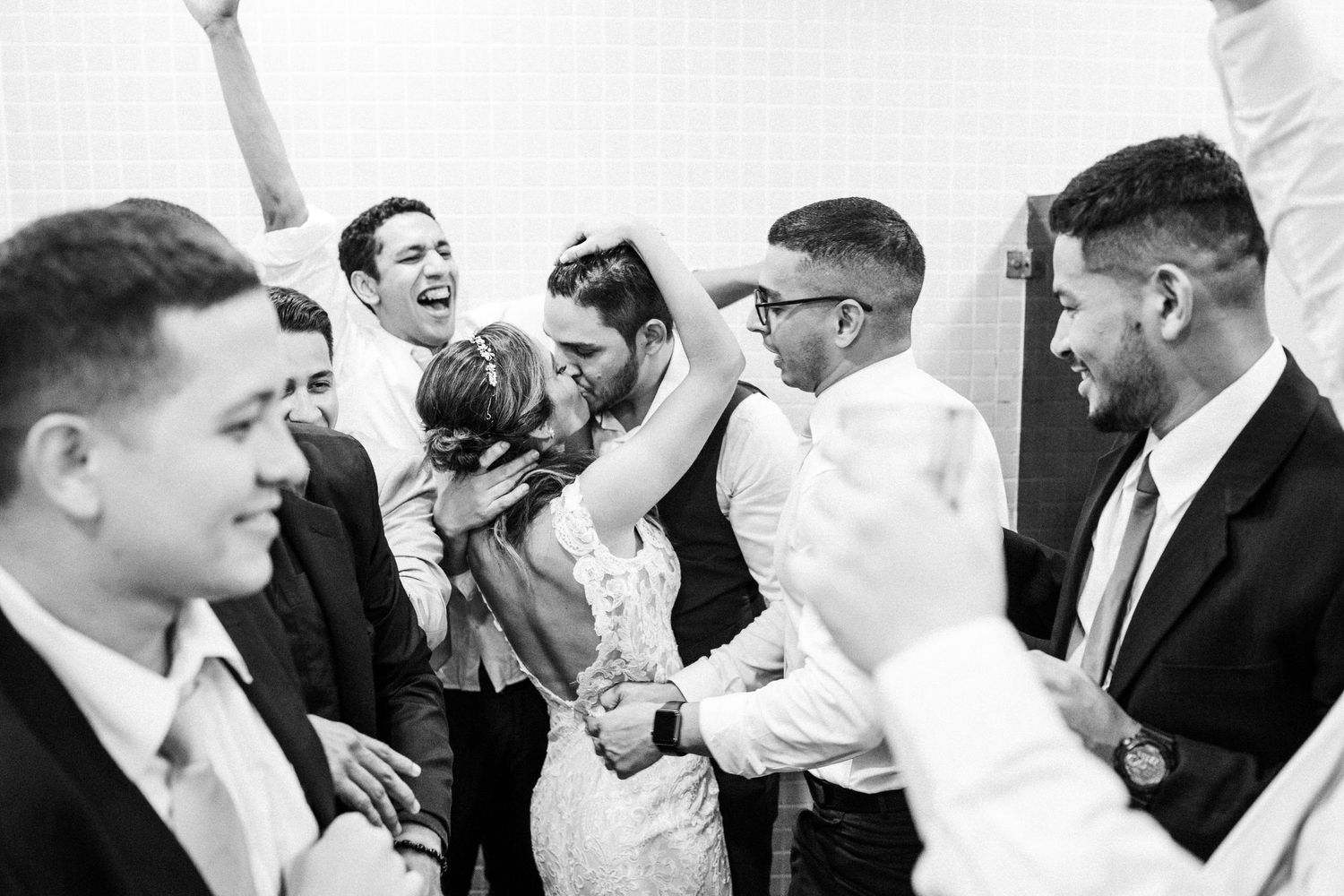 A collection of candid black and white wedding photos showing joyful moments of laughter and celebration.