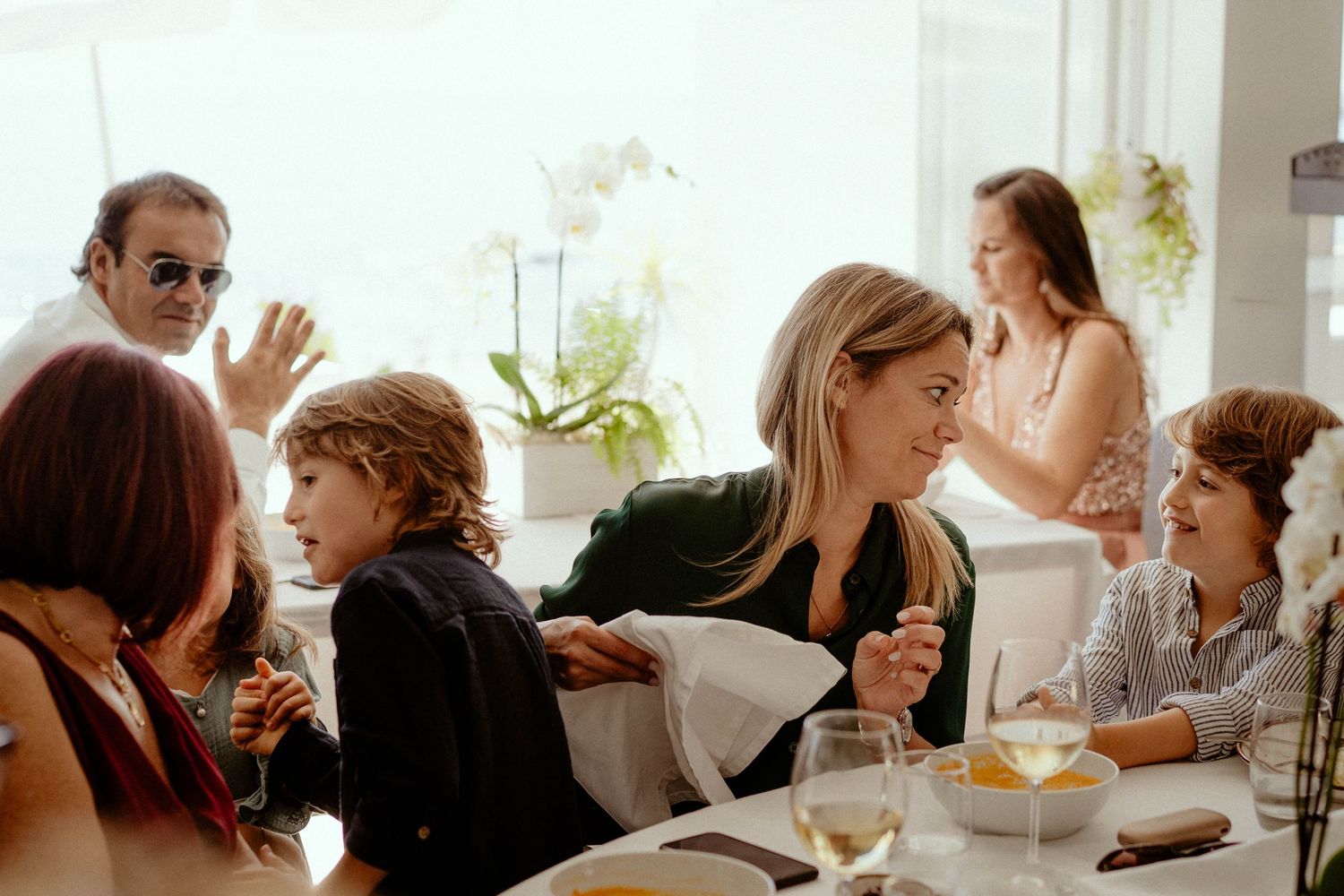 A group of people sitting at a restaurant table enjoying a meal and conversation together.