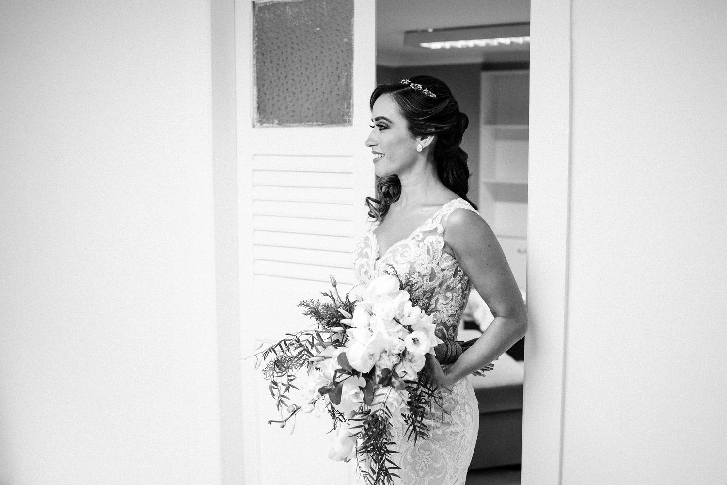 A series of black and white wedding photos showing a person holding a bouquet while getting ready for their ceremony.