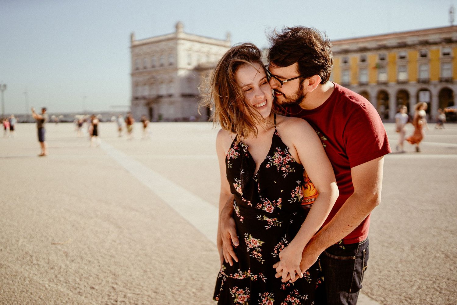 A couple shares romantic moments while exploring historic streets and squares in Lisbon, Portugal in summer.