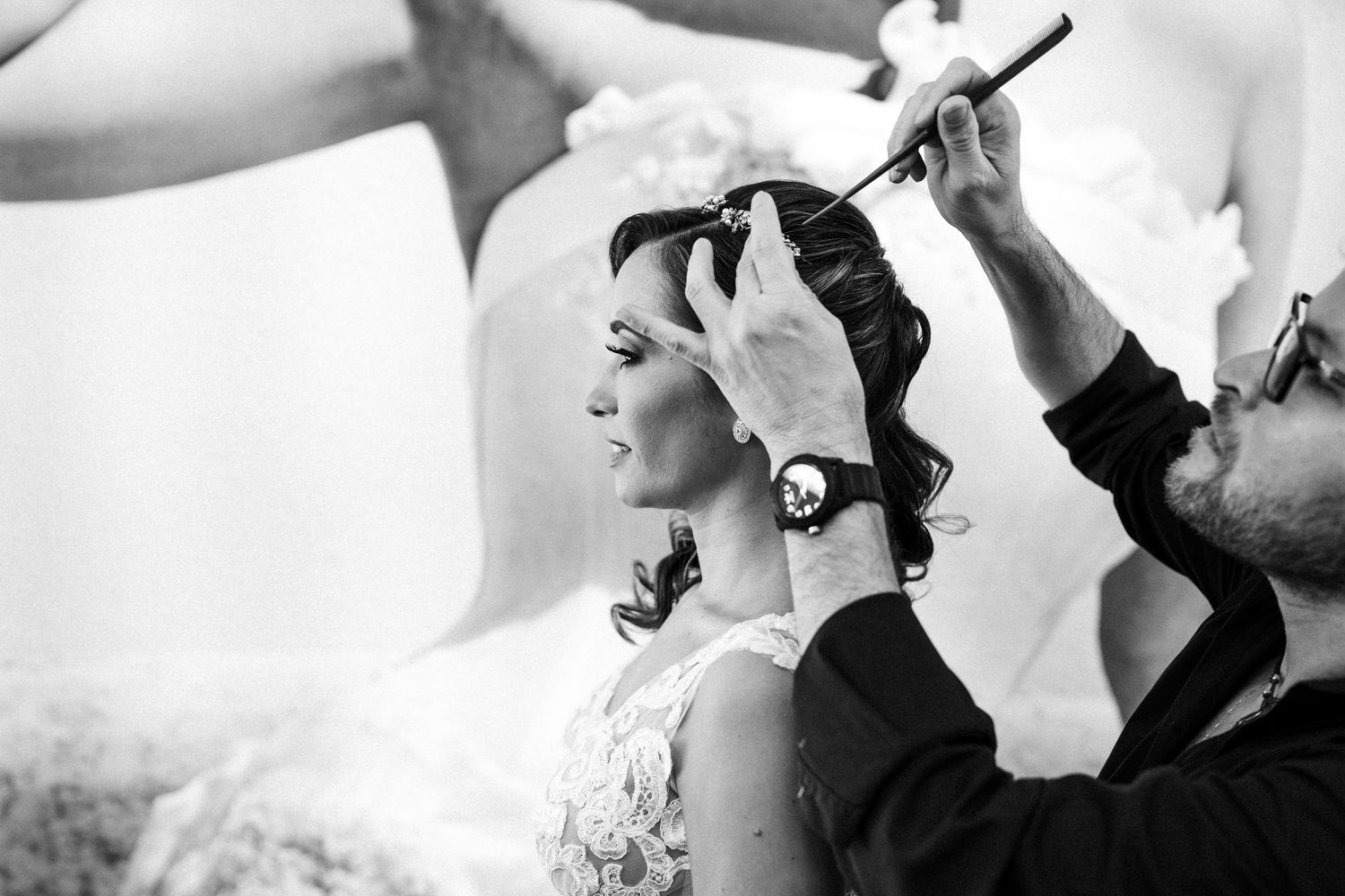 Black and white photo of hairstyling preparation during wedding day preparations.