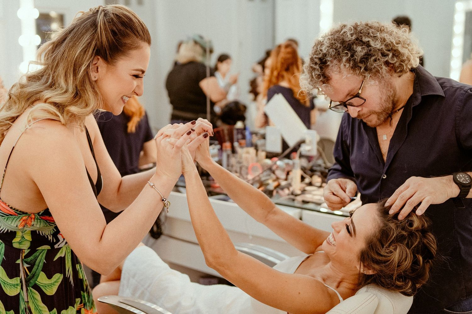 Wedding couple shares intimate moments during their reception with guests seated at dining tables in the background.