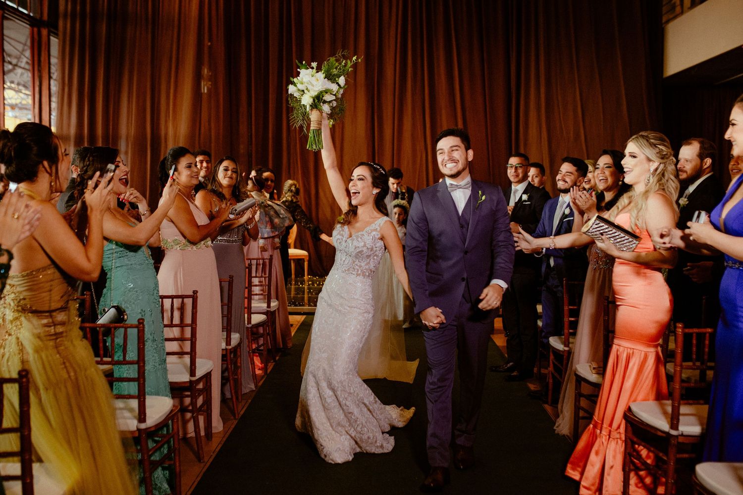 Wedding guests dance and celebrate together on a large dance floor during an elegant evening reception.