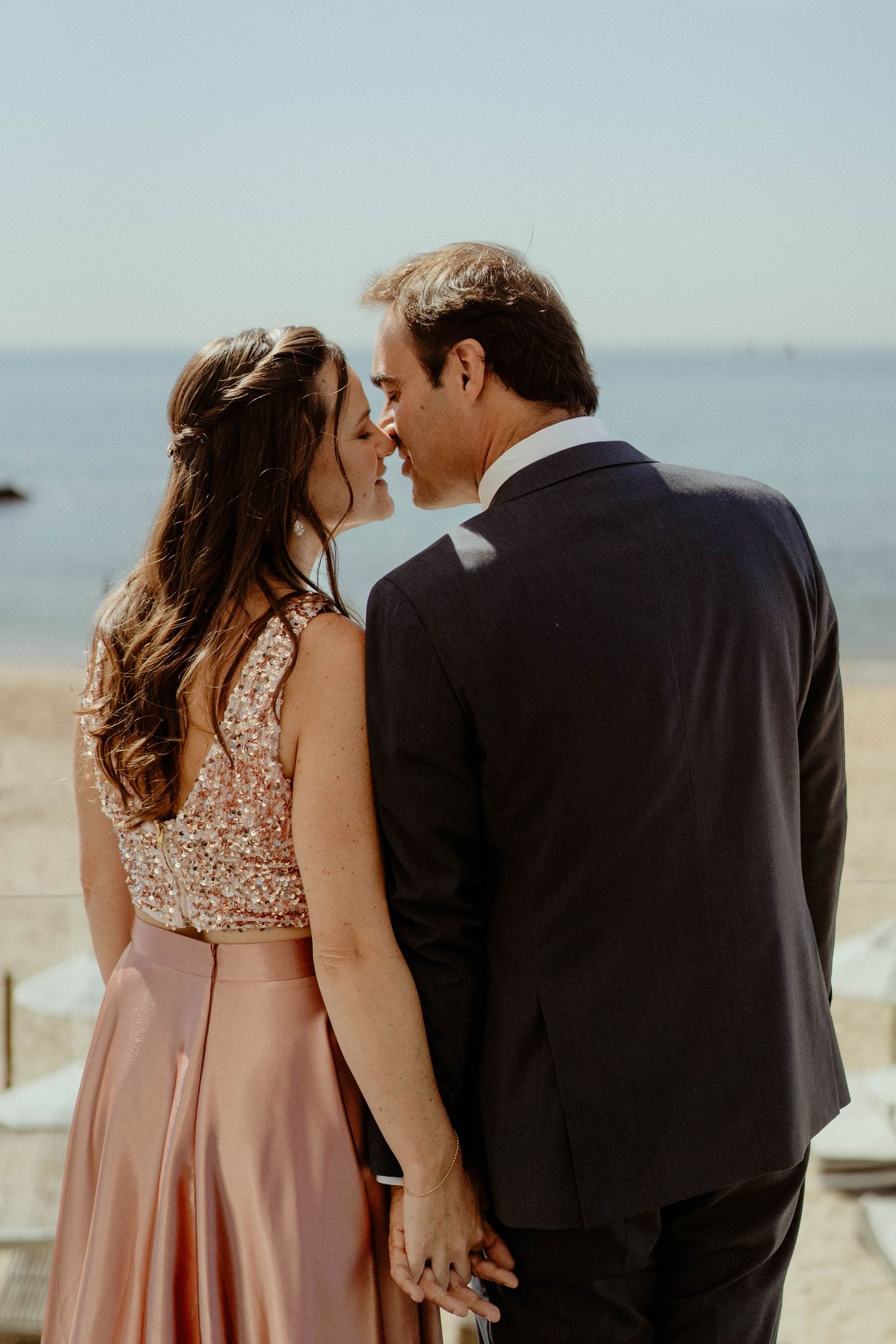 A couple shares an intimate moment in formal attire against a soft blurred background in a series of photos.